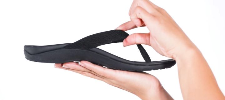 Inspecting the strap of the orthopedic flip flops